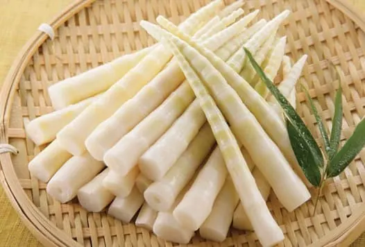 Brotes de bambú pelados sobre una bandeja de bambú trenzado