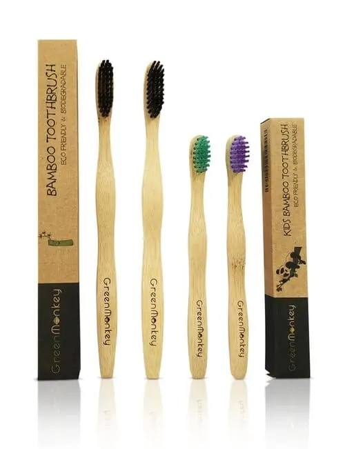 Cepillos de dientes de bambú con cerdas de colores junto a sus cajas de cartón